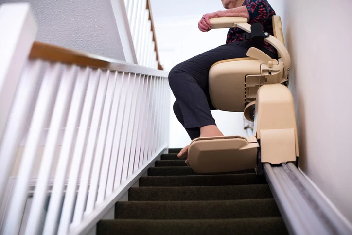 Person using a stairlift, an example of how occupational therapy promotes independent living through adaptive equipment.