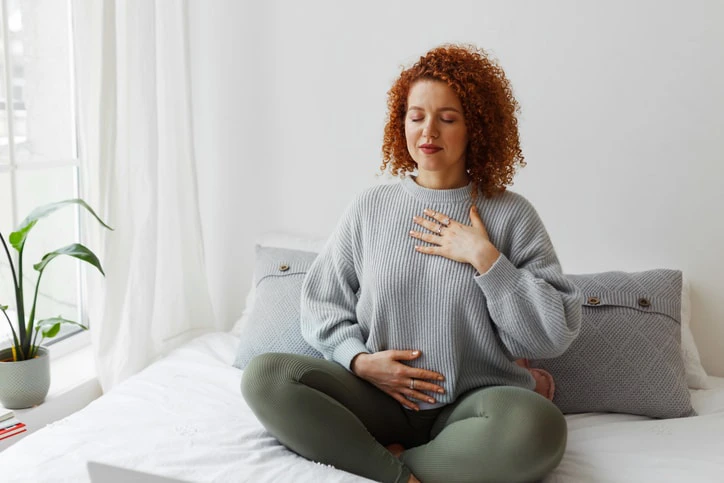 Woman practising breathing exercises, showing occupational therapy's role in teaching relaxation and mindfulness techniques.