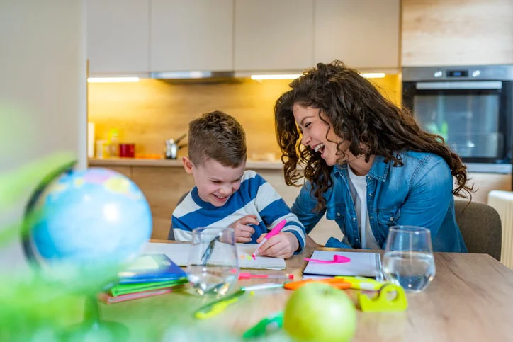 A mother and her autistic child engaged in an occupational therapy activity at home, focusing on improving fine motor skills and daily tasks.