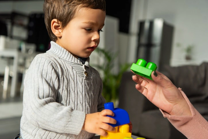 Child engaged in occupational therapy with blocks