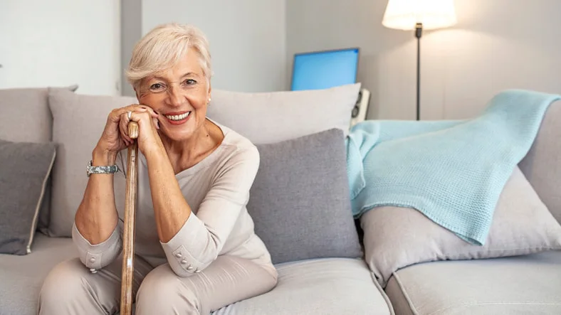 Elderly woman at home using mobility aid given to her by her rehabilitation occupational therapist